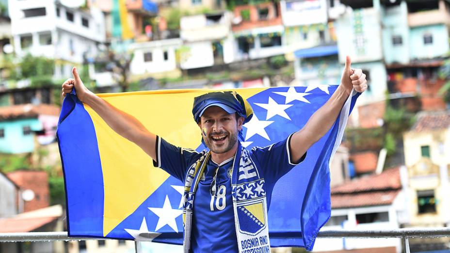 Um torcedor da Bósnia carrega a bandeira do país durante partida contra o Irã, em Salvador