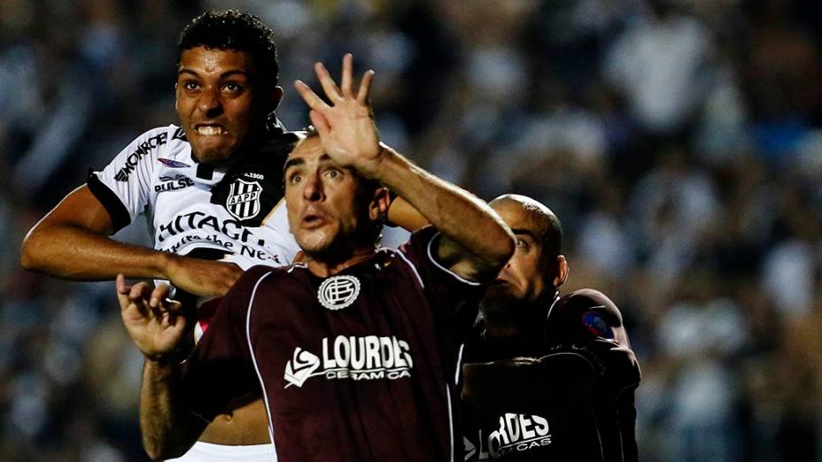 Zagueiro Cesar da Ponte Preta disputa pelo alto com González durante a primeira partida da final da Copa Sul Americana 2013, contra o Lanús, no Pacaembu, em São Paulo