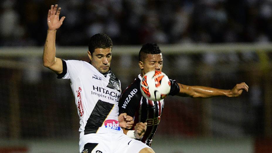 Atacante Leonardo da Ponte Preta divide jogada com o zagueiro Antônio Carlos do São Paulo durante a semifinal da Copa Sul-Americana, no estádio Romildão, em Mogi Mirim