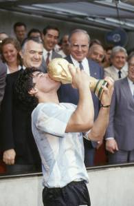 Maradona beijando o troféu da conquista da Copa do Mundo de Futebol, no Estádio Azteca
