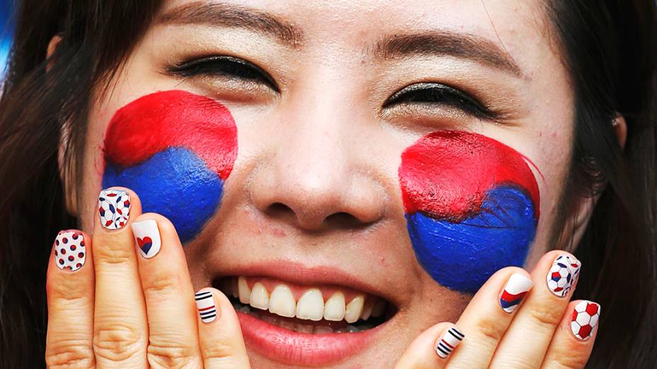 Torcedora pinta a bandeira da Coreia do Sul no rosto para partida contra a Rússia na Arena Pantanal, em Cuiabá