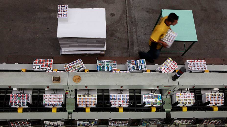 Funcionários trabalham na linha de montagem da fábrica da Panini, que produz as figurinhas do álbum da Copa do Mundo, em Tamboré (SP)