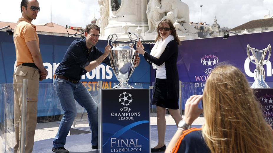 Casal posa para foto junto ao troféu da Liga dos Campeões, em Lisboa