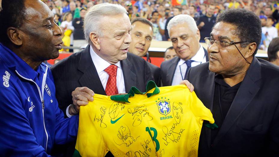 Eusébio recebe uma camisa autografada da Seleção Brasileira das mãos de Pelé e José Maria Marín antes de um amistoso entre Brasil e Portugal, em Foxborough, Massachusetts, em setembro de 2013