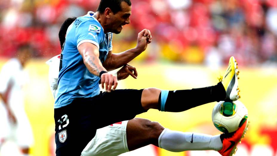 Jogador Matias Aguirregaray do Uruguai, disputa a bola com o taitiano Nicolas Vallar,  pela Copa das Confederações, na Arena Pernambuco