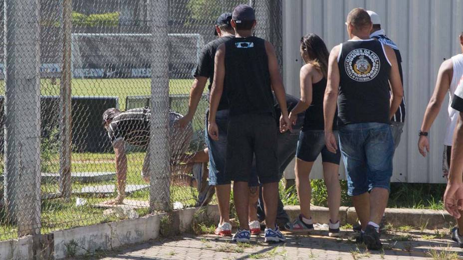 Torcedores abrem um buraco na grade e invadem o CT Corinthians antes do treino do time, em São Paulo