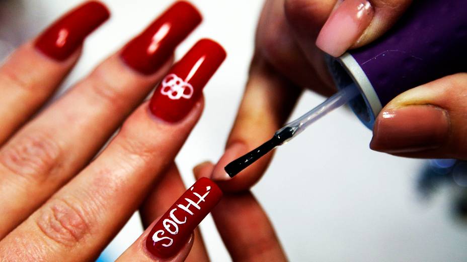 Uma mulher tem as unhas pintadas com os anéis olímpicos no salão de beleza em Sochi, nesta segunda-feira (10)