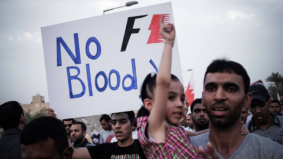 Manifestante segura cartaz contra o próximo Gp de Fórmula 1 do país durante uma manifestação anti-regime, em apoio de ativistas políticos detidos na prisão na aldeia de Jid Ali, nordeste da Isa Town, no Bahrein