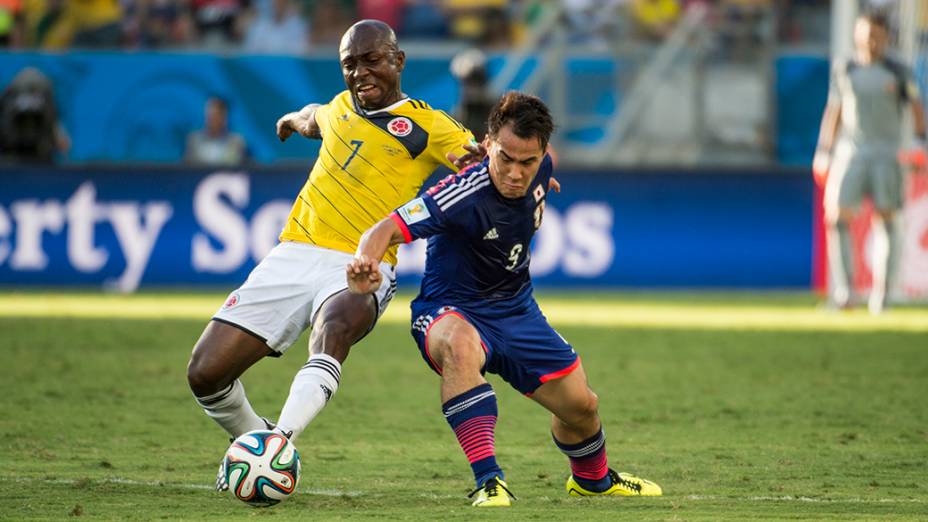 O colombiano Pablo Armero marca o jogador do Japão