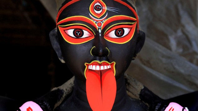 Estátua de barro da deusa negra “Kali” feita durante os preparativos para a celebração do festival Diwali em Calcutá, na Índia
