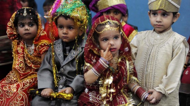 Estudantes indianos vestidos como noivos durante comemoração do Dia das Crianças na cidade de Amritsar, na Índia