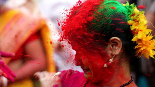 Estudantes jogam pós coloridos uns nos outros durante celebração do Festival das Cores em Calcutá, Índia