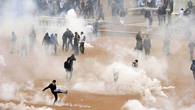 Estudantes se protegem do gás lacrimogêneo lançado pela polícia, em Lyon