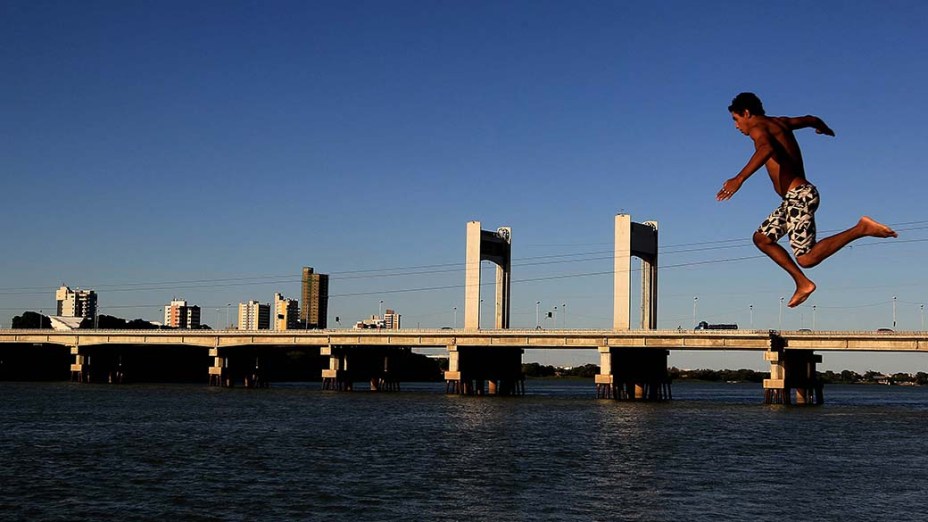 Garotos brincam no rio São Francisco. Ao fundo, a Ponte que liga Petrolina (PE) a Juazeiro (BA)