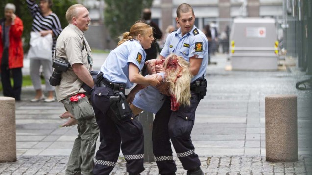 Mulher ferida é socorrida após a explosão em Oslo, Noruega