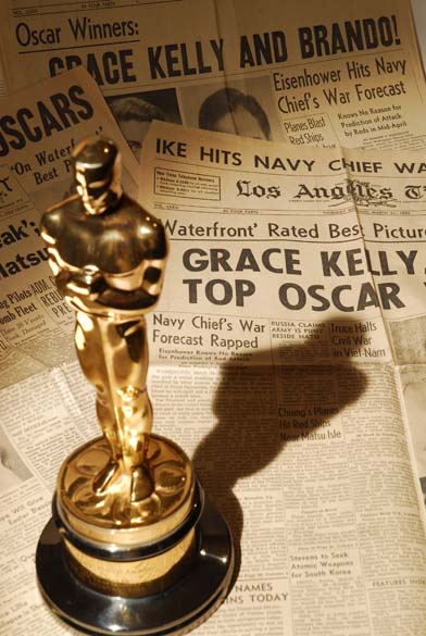 Recortes de imprensa de 31 de março de 1955 e estatueta do Oscar