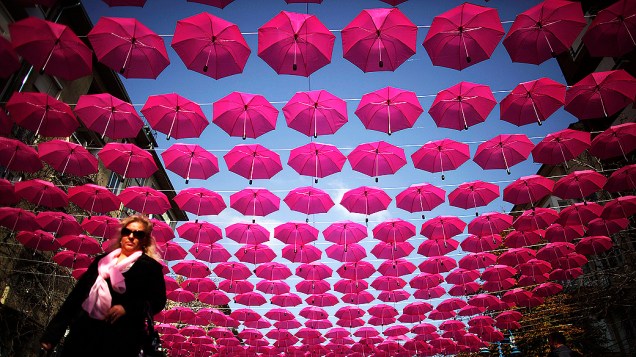 Mulher observa instalção de guarda-chuvas, em Sófia, na Bulgária; a instalação de arte, que inclui até 400 guarda-chuvas, é parte de uma campanha que visa a prevenção, conscientização e tratamento do câncer de mama Mulher observa instalção de guarda-chuvas, em Sófia, na Bulgária; a instalação de arte, que inclui até 400 guarda-chuvas, é parte de uma campanha que visa a prevenção, conscientização e tratamento do câncer de mama