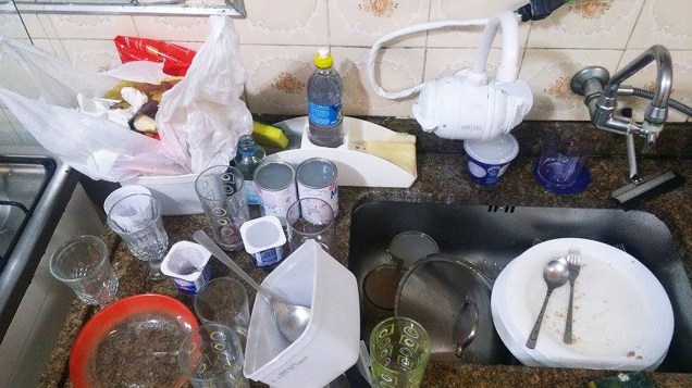 O estudante Marco Luiz acumula copos, pratos, talheres e recipientes para lavar na manhã seguinte, quando o fornecimento de água é retomado
