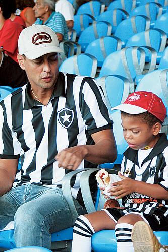 O ator Marcelo Anthony assiste a um jogo do Botafogo, em 1999, com o filho adotivo, Francisco.