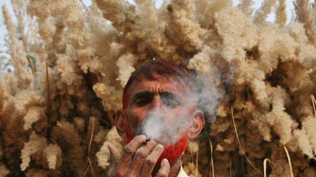 Fazendeiro fuma um bidi, cigarro indiano feito de folhas da vegetação nativa, em Jammu, na Índia
