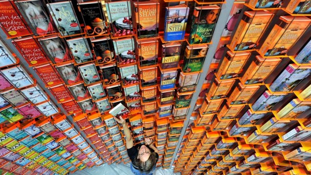 Funcionária organiza livros na Feira de Livros de Frankfurt, o maior evento do mercado literário do mundo