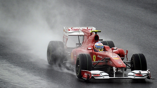 Fernando Alonso controla a direção da sua Ferrari na pista molhada
