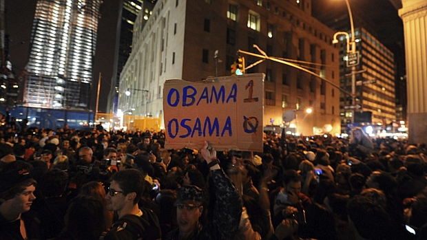 Homem segura cartaz aludindo à vitória do presidente americano sobre o chefe da rede terrorista Al Qaeda; especialistas avaliam que popularidade de Obama suba entre os americanos.