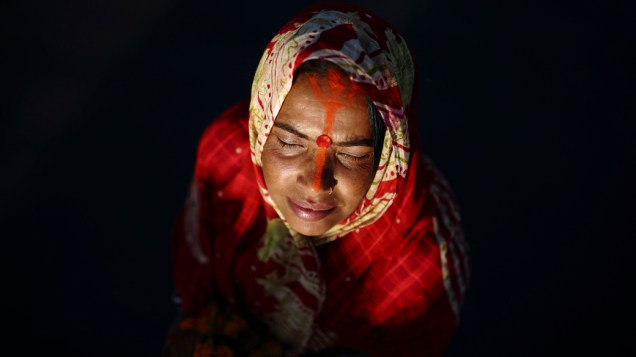 Mulher oferece oração durante o festival "Chhat" no rio Bagmati em Katmandu, Nepal