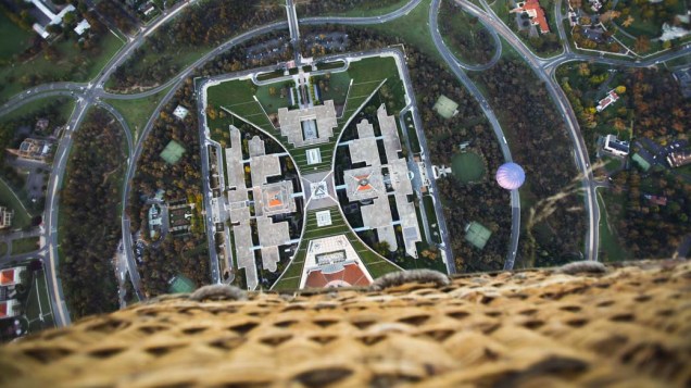 Vista do Parlamento Federal australiano durante o "Balloon Spectacular" do festival de Canberra, Austrália. O evento é um dos poucos que permite que os balões sobrevoem prédios governamentais