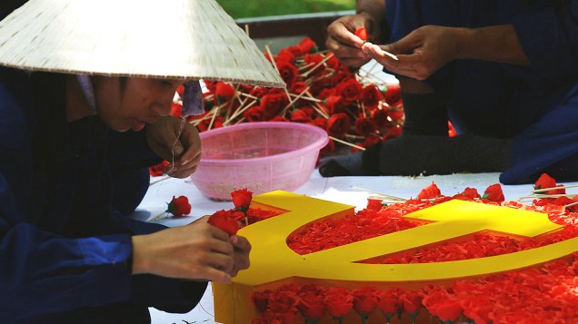 Trabalhadores preparam uma bandeira feita com flores para o dia da independência no próximo dia dois de setembro, em Hanói (Vietnã)