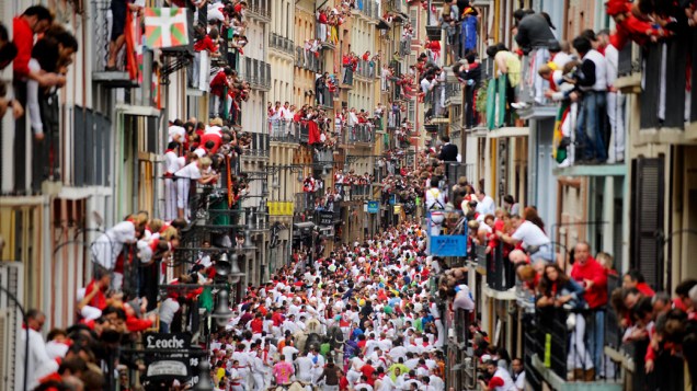 Multidão assiste a tradicional corrida de touros durante o festival de São Firmino em Pamplona, Espanha