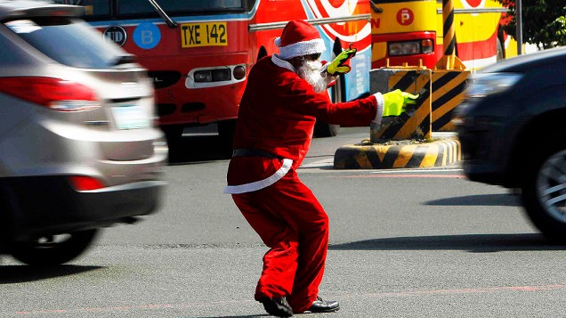 Vestido de Papai Noel, agente organiza o trânsito em avenida na cidade de Manila, nas Filipinas