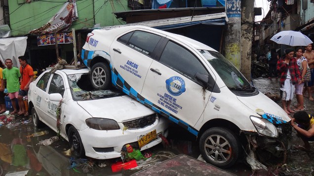 Carros são empilhados após enchente, nas Filipinas