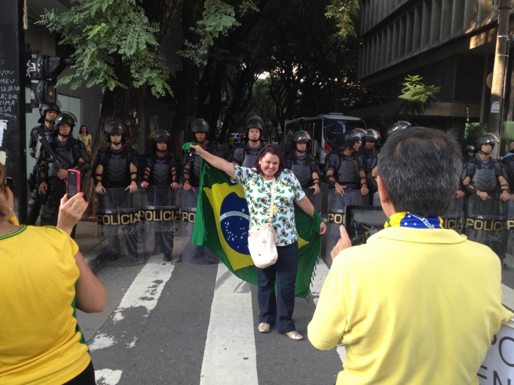 Fatima Claros Rosales, de 60 anos, posa para fotos com agentes da Polícia Militar da Força Tática na Avenida Paulista, em São Paulo