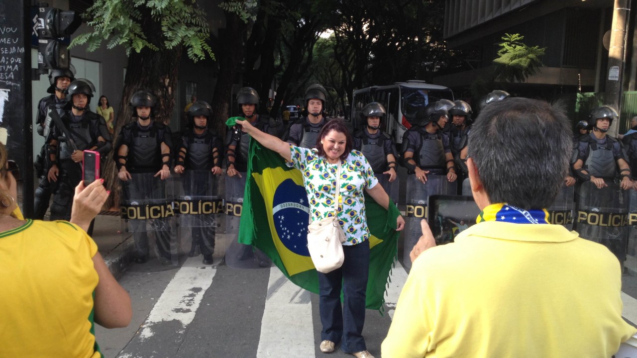 Fatima Claros Rosales, de 60 anos, posa para fotos com agentes da Polícia Militar da Força Tática na Avenida Paulista, em São Paulo