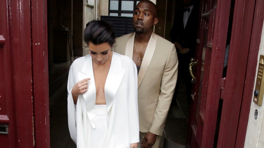 Kanye West e Kim Kardashian ao sair de sua residência em Paris