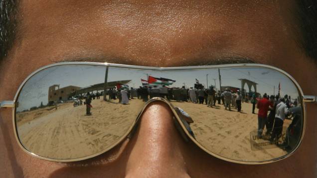 Homem observa fila de palestinos aguardando para atravessar a fronteira entre Egito e a Faixa de Gaza, fechada desde 2007. Logo após a abertura, centenas de pessoas cruzaram a fronteira em direção ao Egito