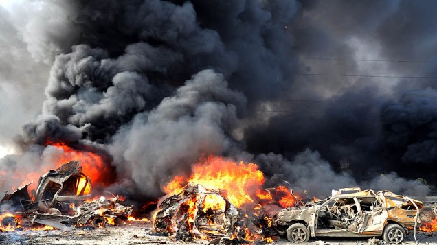 Carros pegam fogo após explosão de duas bombas que provocaram 55 mortes e deixam dezenas de pessoas feridas em Damasco, na Síria