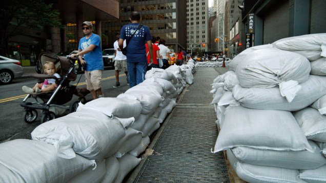 Pedestres passam por sacos de areia colocados no centro de Nova York