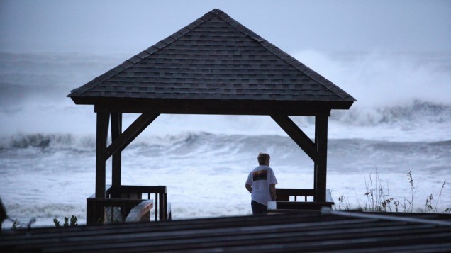 Homem observa ondas em praia da Carolina do Norte, durante a passagem do furacão Irene