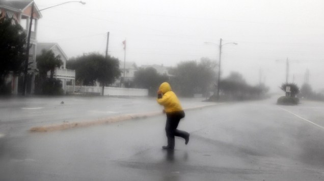Pedestre atravessa área aberta durante a passagem do furacão Irene, na Carolina do Norte