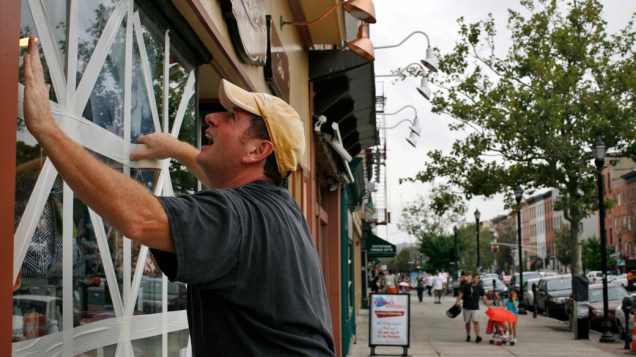Homem reforça as janelas de estabelecimento comercial antes da passagem do furacão Irene, em Nova Jersey