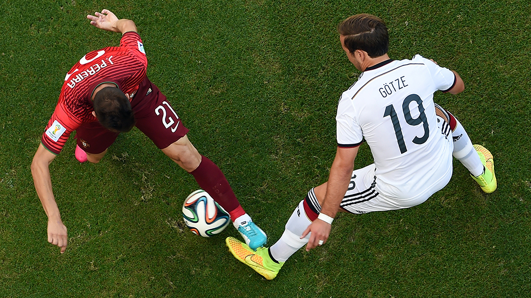 João Pereira, de Portugal, disputa a bola com o alemão Mario Götze na Arena Fonte Nova, em Salvador, em duelo da Copa do Mundo