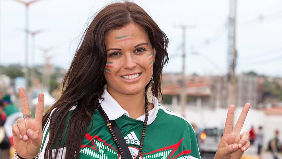 Torcedora pinta o rosto com as cores da bandeira do México antes do jogo contra o Brasil no Castelão, em Fortaleza