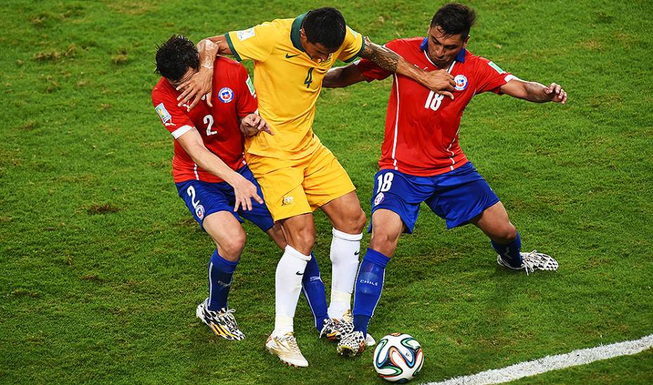 Tim Cahill, da Austrália, disputa a bola com dois jogadores do Chile, na Arena Pantanal em Cuiabá