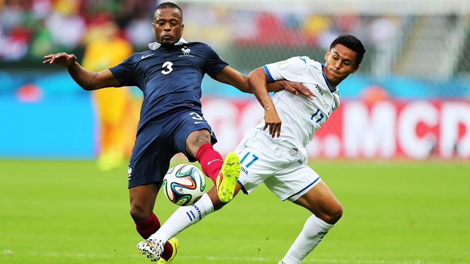 O francês Patrice Evra disputa a bola com Andy Najar, de Hondura, no Beira-Rio em Porto Alegre