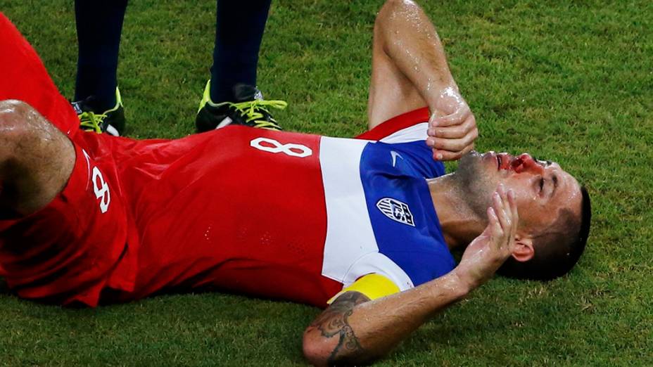 Sangue escorre do nariz do americano Clint Dempsey após lance com jogador de Gana