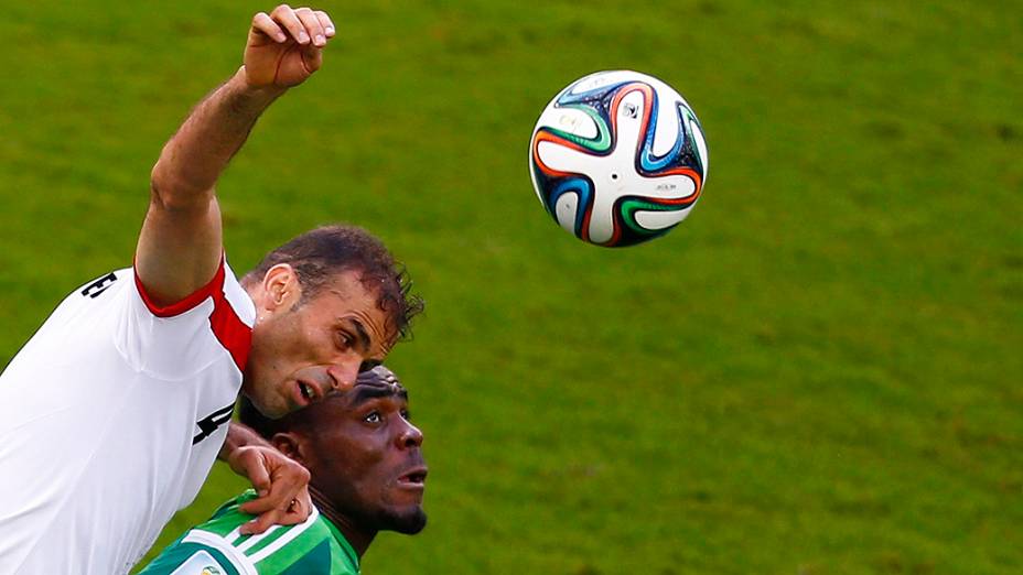 O iraniano Jalal Hosseini disputa a bola com Emmanuel Emenike, da Nigéria, na Arena da Baixada em Curitiba