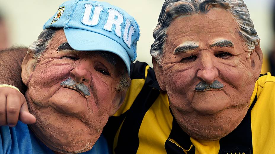 Torcedores do Uruguai usam máscara do presidente José Mujica antes do jogo contra a Costa Rica, no Castelão em Fortaleza