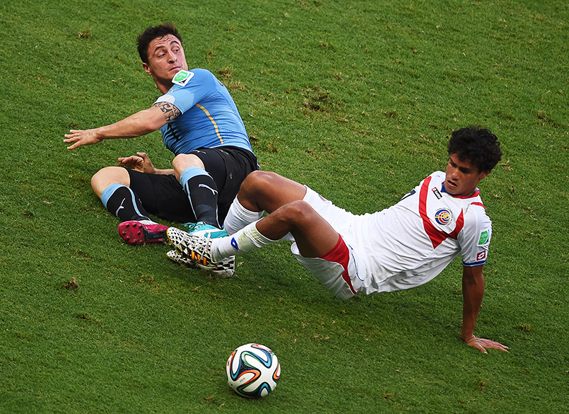 Cristian Rodriguez, do Uruguai, disputa a bola com Yeltsin Tejeda, da Costa Rica, em Fortaleza